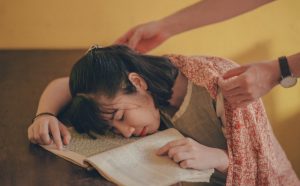 Girl asleep with head in her book